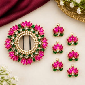 May include: A circular hair accessory and six matching individual hair pins, each featuring a lotus flower design with vibrant pink petals, green accents, clear square crystals, and a border of small white pearls set in a gold-toned metal frame.