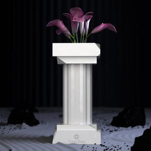 May include: A white, fluted column with a square top and base, holding several purple calla lilies. The column has a geometric design and the text "Torus Knot" is visible on the base. The background is dark with a zen garden.