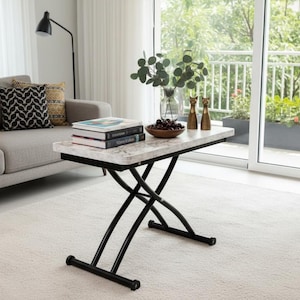 Könnte beinhalten: Ein modernes Wohnzimmer mit einem Couchtisch mit Marmor-Optik und schwarzen Metallbeinen. Auf dem Tisch liegen Bücher, eine Schale mit Obst und Dekorationsartikel. Ein graues Sofa mit gemusterten Kissen ist in der Nähe.