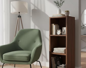 Könnte beinhalten: Ein modernes Wohnzimmer mit einem grünen Sessel, einem Holzregal und einer Stehlampe. Das Regal ist mit Büchern, einer Uhr und Dekorationsartikeln gefüllt. Der Sessel hat eine geschwungene Rückenlehne und schwarze Beine. Die Lampe hat einen beigen Schirm.