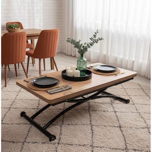 May include: A light wood-tone lift-top coffee table with black metal legs. The table is set with black plates, woven placemats, and silverware. A green glass vase with greenery and candles sits on top. The room has orange chairs and a patterned rug.