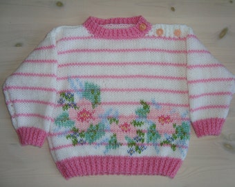 Handknitted babysweater, pink and white with flowers