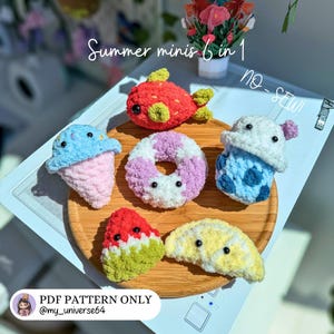Könnte beinhalten: Eine Sammlung von fünf gehäkelten Plüschfiguren, darunter ein roter Fisch, eine rosa-blaue Eiswaffel, ein lila-weißer Donut, ein blaues Getränk, ein Wassermelonenstück und eine Zitronenscheibe, mit dem Text Summer minis 6 in 1 no-SEW!