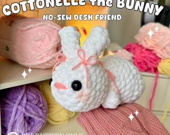 May include: A white crocheted bunny with pink accents, including a bow and blush. The text "Cottonelle the Bunny" and "No-Sew Desk Friend" are displayed. The image also shows various yarn colors.
