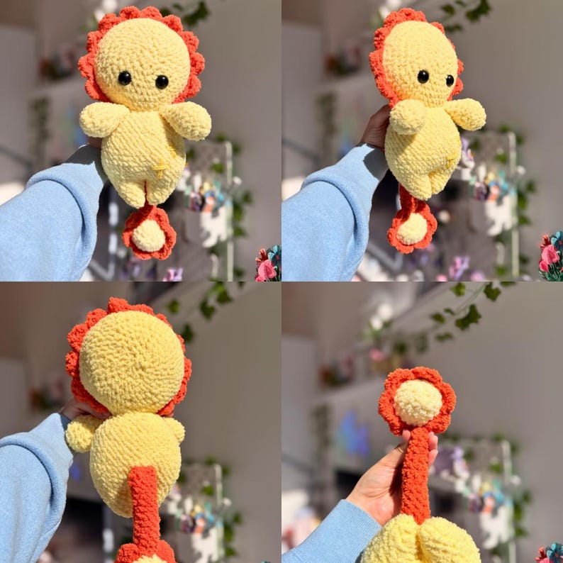 Op de afbeelding: Een handgemaakte gehaakte leeuwenpop in geel en oranje. De leeuw heeft een ronde kop met een rode manen, kleine zwarte ogen en een gele body. De pop houdt een bloemvormig stuk vast. De pop is ongeveer 15 cm hoog.