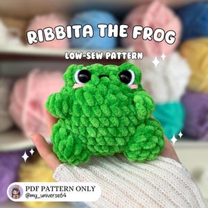 Puede incluir: Un peluche de rana verde tejido a ganchillo con ojos negros y detalles rosas. El texto "RIBBITA THE FROG" y "LOW-SEW PATTERN" están sobre la rana. El texto "PDF PATTERN ONLY @my_universe64" está debajo. La rana está hecha de hilo suave y texturizado.