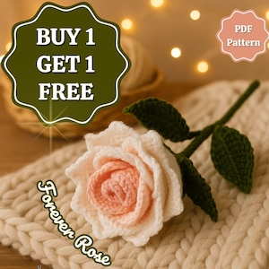 May include: A crocheted rose with a cream-colored outer layer and a soft pink center, resting on a cream-colored knitted surface. The rose has green leaves and stem. The image includes text that says "Forever Rose" and "BUY 1 GET 1 FREE".