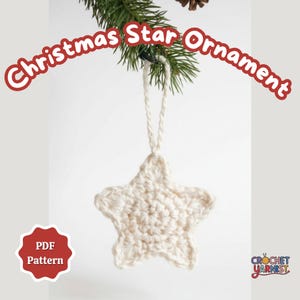 Könnte beinhalten: Ein cremefarbener, gehäkelter Sternschmuck, der an einem Kiefernzweig hängt. Der Stern hat eine Schlaufe zum Aufhängen und ist mit einem strukturierten Stich gefertigt. Der Text auf dem Bild lautet "Christmas Star Ornament" und "PDF Pattern".
