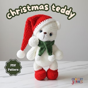 May include: A handmade white crochet teddy bear wearing a red and white Santa hat, a green scarf, and red boots. The text "christmas teddy" is arched above the bear. A green and white PDF pattern logo is on the left.