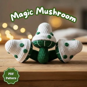 Puede incluir: Figuras de setas de ganchillo en blanco y verde, con el texto "Magic Mushroom" encima. Las setas tienen sombreros blancos con lunares verdes y tallos verdes. Una insignia de "PDF Pattern" está en la esquina inferior izquierda.
