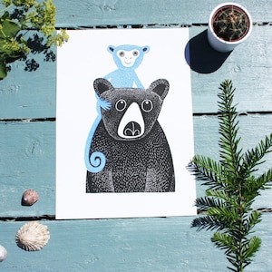 May include: A black and white illustration of a bear with a blue monkey sitting on its back. The monkey has a white face and large eyes.