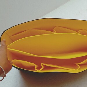 May include: Yellow fabric organiser with multiple compartments for a tote bag.