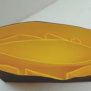 May include: A black fabric organiser with yellow fabric dividers. The organiser has multiple compartments for storing items.