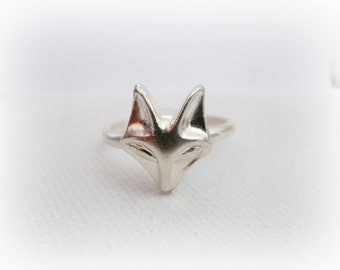 Può includere: Un anello d'argento a forma di testa di volpe. L'anello è in metallo e presenta un design dettagliato della testa di volpe.