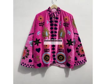 May include: A bright pink jacket featuring a mandarin collar and long sleeves, adorned with multi-colored floral and heart-shaped embroidery. The front opening is lined with dark blue decorative trim, and the text CraftofIndianShop is visible.