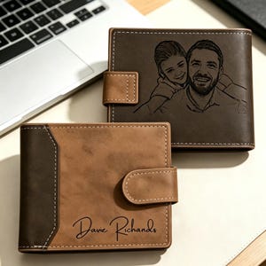 May include: Two brown leather bi-fold wallets with snap closures and white stitching. One wallet features a laser-engraved portrait of a person smiling behind another person. The other wallet displays the engraved name Davie Richards in script.