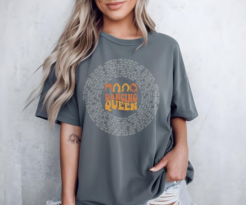 A woman wearing a gray t-shirt with the text "DANCING QUEEN" printed on it.