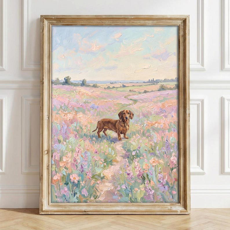 May include: An oil painting in a wooden frame depicting a brown dachshund standing in a field of pastel pink, purple, and green wildflowers under a soft blue and peach sky. The artwork features visible brushstrokes and a textured impasto style.