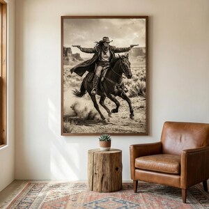 May include: Sepia-toned framed print of a person riding a horse in a desert landscape, holding two guns. The person wears a hat and long coat, arms outstretched. The horse is galloping, kicking up dust. Western-themed art.