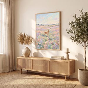 May include: A rectangular wall art print featuring an oil painting of a golden dog standing in a vibrant field of pink, purple, and blue wildflowers under a soft pastel sky. The artwork is displayed in a thin wooden frame on a light-colored wall.