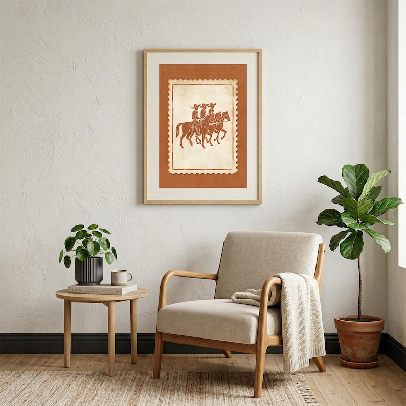 May include: A framed wall art print featuring a postage stamp design with a terracotta background. The central illustration depicts three figures riding horses in a line, rendered in a dark brown outline style on a cream-colored textured background.