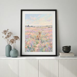 May include: A framed painting depicts a golden retriever sitting in a field of colorful wildflowers. The artwork features a soft, impressionistic style with pastel colors, a blue sky, and a distant landscape. The painting is displayed in a black frame.