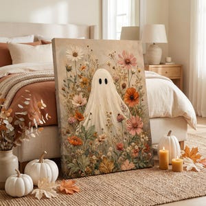 May include: A rectangular canvas print featuring a central white ghost figure surrounded by a dense arrangement of wildflowers in shades of orange, pink, white, and green. The artwork displays a textured, painterly style with visible brushstrokes.