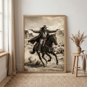 May include: Sepia-toned framed print of a person riding a horse through a desert landscape. The person, wearing a cowboy hat and duster, holds two pistols. The horse is galloping, kicking up dust. The artwork evokes a Western theme.