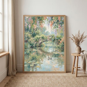 May include: A framed painting depicts a serene waterscape with a stone bridge, lush greenery, and colorful hanging flowers. A duck swims in the water, reflecting the sky and surrounding foliage. The artwork is in a wooden frame.