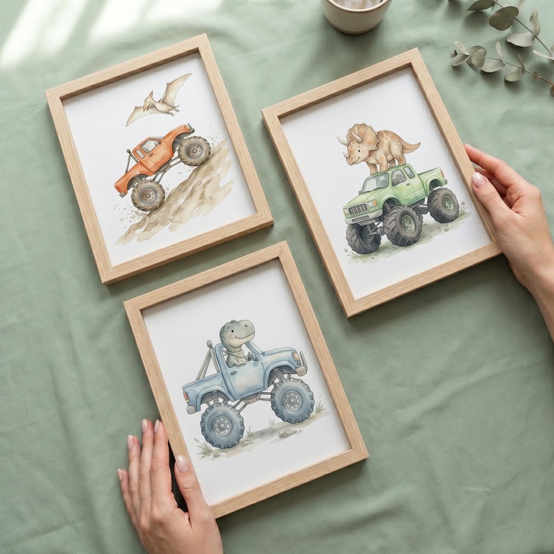 Puede incluir: Tres impresiones enmarcadas en acuarela con monster trucks y dinosaurios. Una impresi&oacute;n muestra un cami&oacute;n naranja con un Pterod&aacute;ctilo, otra un cami&oacute;n verde con un Triceratops y la &uacute;ltima un cami&oacute;n azul con un T-Rex. Los marcos son de color marr&oacute;n claro.