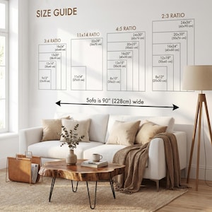 May include: A living room scene with a white sofa, wooden coffee table, and a floor lamp. The wall displays a size guide for artwork, including dimensions in inches and centimeters. The sofa is 90 inches (228cm) wide.