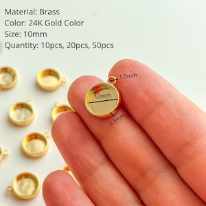 Peut inclure: Des pendentifs ronds en laiton couleur or 24 carats, de 10 mm de diamètre. L'image montre les dimensions d'un pendentif : une boucle de 1,5 mm et une profondeur de 3,5 mm. Disponibles en quantités de 10, 20 ou 50 pièces.