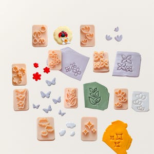 Könnte beinhalten: Set aus drei Keramikbechern mit gesprenkelter, matter Oberfläche. Die Becher sind in Creme-, Hellgrau- und Dunkelgrautönen gehalten. Jeder Becher hat ein schlichtes, minimalistisches Design.
