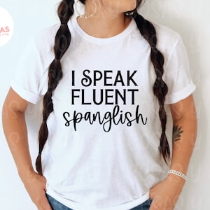 Può includere: T-shirt bianca con la scritta nera "I SPEAK FLUENT SPANGLISH". La maglietta è a girocollo e ha maniche corte. L'immagine include anche il testo "instant download svg png jpg".