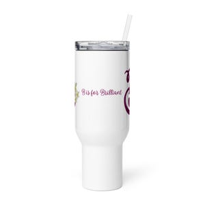 Pode incluir: Caneca branca com tampa prateada e canudo transparente. A caneca apresenta o texto "B is for Brilliant" em uma fonte bordô, juntamente com um design floral. A caneca foi projetada para conter bebidas frias.