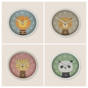 Könnte beinhalten: Vier runde Wanduhren mit Tiergesichtern: ein Löwe, ein Bär, eine Katze und ein Panda. Jede Uhr hat einen weißen Rahmen, einen farbigen Hintergrund und schwarze Zahlen. Die Löwenuhr hat einen blauen Hintergrund, die Bäruhr einen beigen Hintergrund, die Katzenuhr einen rosa Hintergrund und die Pandauhr einen grünen Hintergrund.