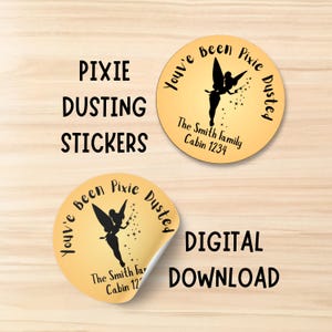 Könnte beinhalten: Runde, goldene Aufkleber mit einer schwarzen Silhouette einer Fee und dem Text "You've Been Pixie Dusted". Die Aufkleber enthalten auch den Text "The Smith Family Cabin 1234". Die Wörter "Pixie Dusting Stickers" und "Digital Download" sind ebenfalls sichtbar.