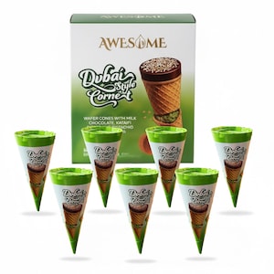 May include: A box of "AWESOME" Dubai Style Cornet ice cream cones with a green and white design. The box and cones feature text and images of the product. The cones are wafer cones with milk chocolate, kataifi, and pistachio.