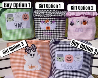May include: Five fabric baskets with gingham patterns in green, black, pink, and orange. Each basket features embroidered Halloween designs including ghosts, pumpkins, and monsters, with personalised names like Slate, Maggie, Laura, Aubrey, and Micheal.