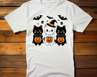 May include: White t-shirt featuring a Halloween-themed graphic. The design includes three cartoon cats, two black and one white, each holding a jack-o'-lantern. Bats, stars, and skulls are also part of the design, creating a festive look.
