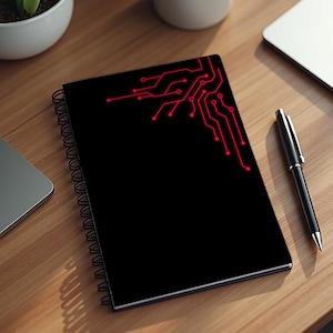 May include: Black spiral-bound notebook with a red circuit board design in the upper corner. The notebook is lying on a wooden surface next to a pen and a laptop.