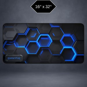 May include: A black and blue gaming mouse pad with a hexagonal pattern and the text "gamertag". The pad measures 16 inches by 32 inches.
