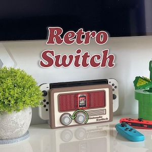 Pode incluir: Uma base Nintendo Switch em estilo retro com o texto "Retro Switch". A base foi projetada para se assemelhar a um rádio antigo, com um esquema de cores marrom e creme. A imagem também mostra os controladores Switch e uma pequena planta.