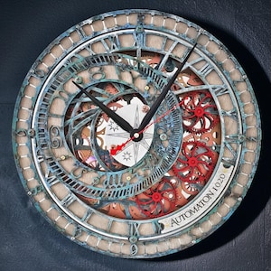 May include: A round wall clock with a layered design featuring Roman numerals, gears, and clock hands. The clock has a distressed, aged appearance with blue, brown, and red accents. The text "AUTOMATON 1020" is visible on the clock face.