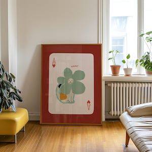 May include: A framed art print featuring a whimsical illustration of a cat disguised as a flower on a playing card. The card is the Ace of Hearts, with the word "meow" above the cat. The frame is gold, and the mat is red.