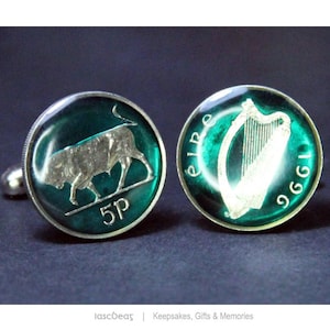 Puede incluir: Gemelos plateados con fondo verde oscuro. Un gemelo presenta un toro plateado y el número "5P". El otro gemelo tiene un arpa plateada y la palabra "Eire" con el año "1996".