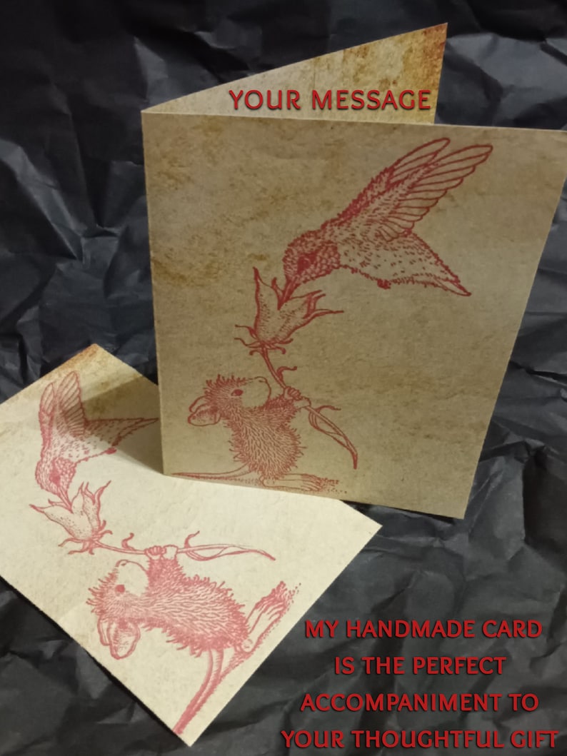 May include: A handmade card with a red hummingbird and a mouse holding onto a flower stem. The card has the text "Your Message" on the front and "My handmade card is the perfect accompaniment to your thoughtful gift" on the back.