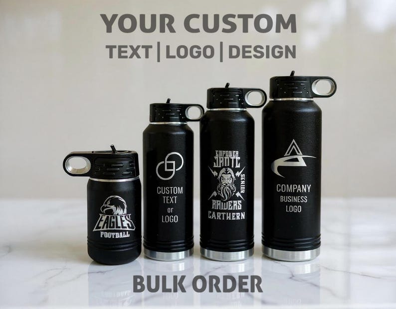 Four black water bottles of varying heights lined up on a white marble surface, each engraved with different custom logos and text.