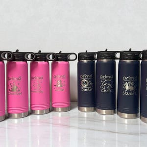 Puede incluir: Una colecci&oacute;n de botellas de agua aisladas en rosa y azul marino. Cada botella tiene una tapa negra con una abertura abatible y una base plateada. Las botellas rosas est&aacute;n grabadas con nombres y gr&aacute;ficos de animales, las azules con nombres y gr&aacute;ficos de animales.