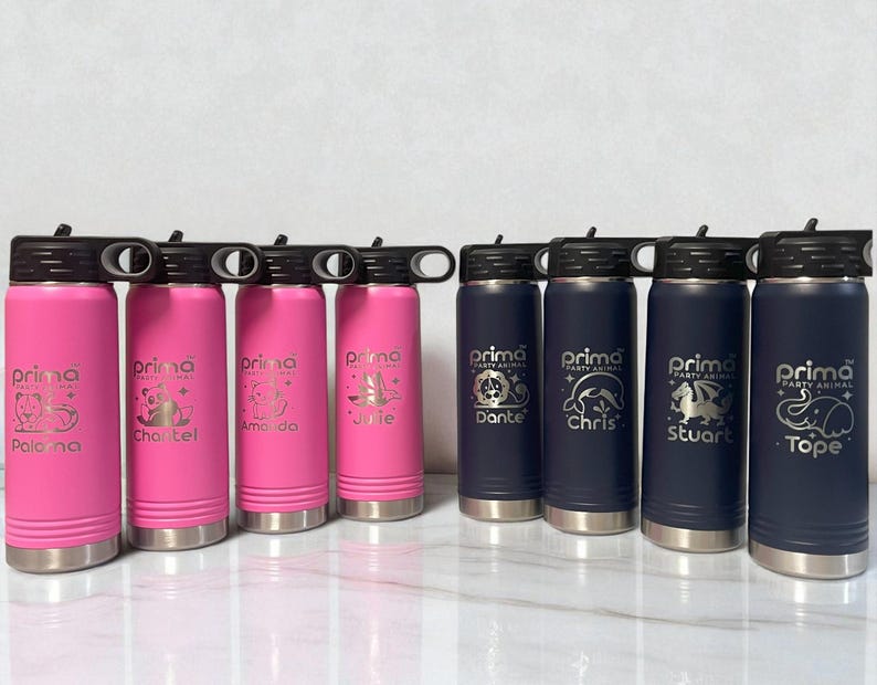 A row of eight insulated water bottles with black lids standing on a white surface, featuring four bright pink bottles on the left and four dark navy blue bottles on the right, all engraved with custom animal graphics and names.